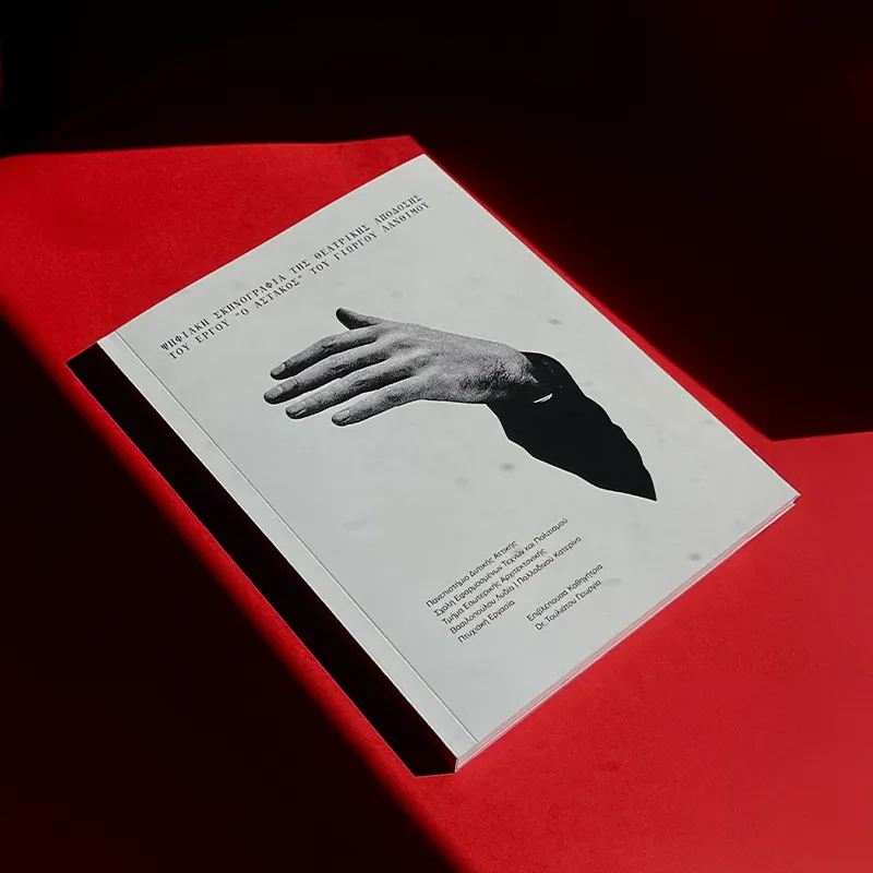 Cover of the bachelor’s thesis “Digital Scenography of the Theatrical Adaptation of Yorgos Lanthimos’ The Lobster” by Katerina Palladinou, photographed on a red background with directional light and shadow.